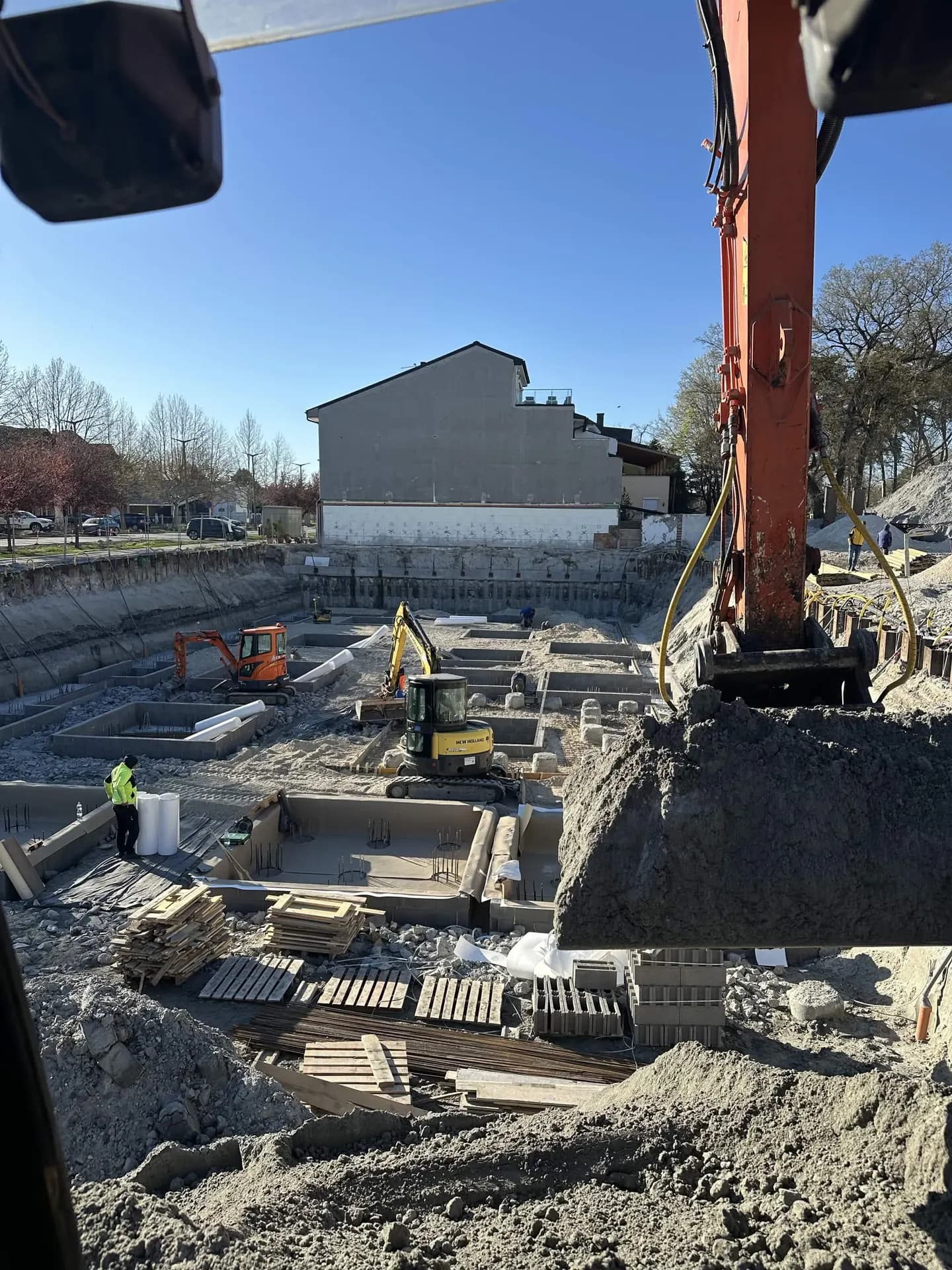Épület alapozási földmunkái, munkagödör kotrókkal