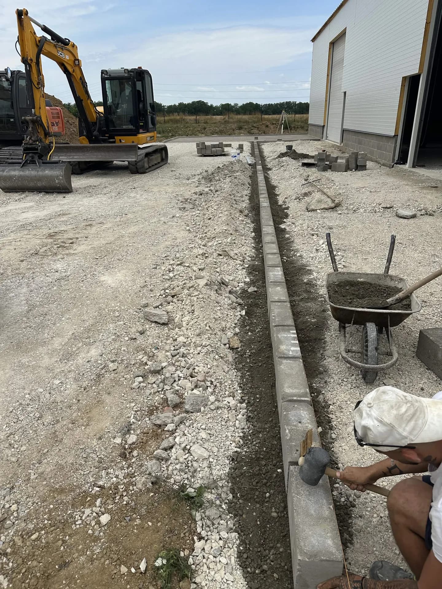 Szegélykő rakása ipari csarnok melletti útépítésnél