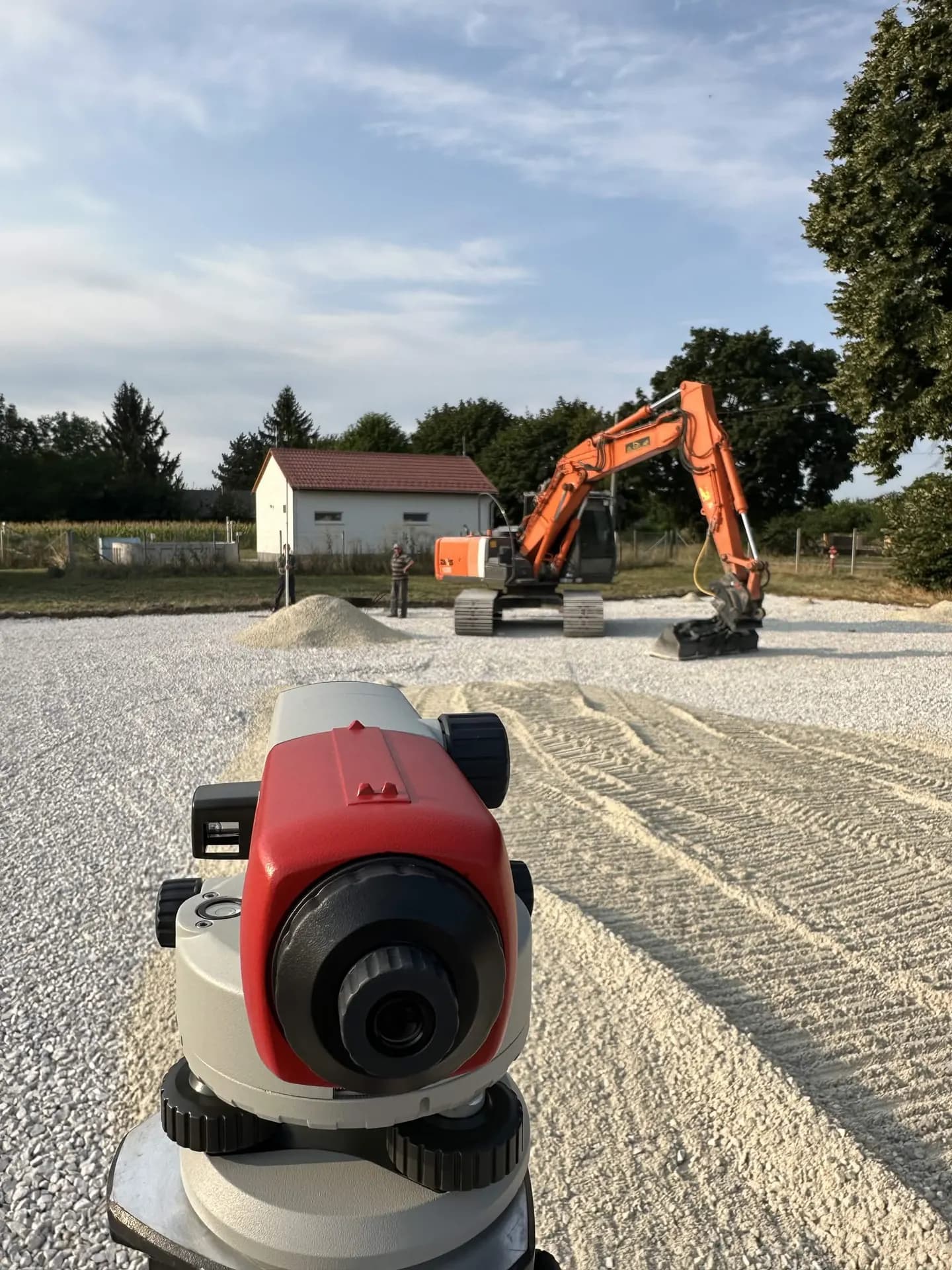 Szintezés a zúzottkő alapon, háttérben kotróval